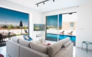 Protaras Holiday Rentals providing luxurious modern living room with indoor-outdoor flow and private pool.