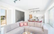 Protaras Holiday Rentals offering modern, airy living space with bright decor, open-plan kitchen, and dining area.