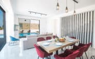 Modern open-plan living and dining area with elegant decor and pool view in Protaras Holiday Rentals.