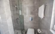 Modern grey tiled bathroom with sleek fixtures in tropical Protaras Holiday Rentals.