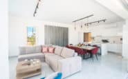 Modern open-plan living area with red chairs, ideal for Protaras Holiday Rentals, Cyprus.