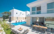 Modern luxury villa with outdoor dining, sunbathing, and pool in Protaras.