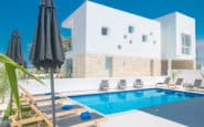 Protaras Holiday Rentals with luxurious poolside setting, modern architecture and sunbeds, ideal for relaxing holidays.