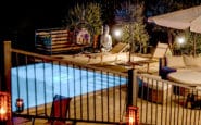 Nighttime poolside lounge area in Villa Aura, Villa in Nicosia with a lit pool and seating