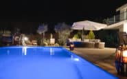 Pool area at Villa Aura in Nicosia with lounge chairs and umbrellas