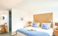 Contemporary bedroom with blue accents, modern lamps, and serene atmosphere in villas-in-protaras.