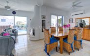 Elegant Mediterranean Cyprus Villa Rent with living and dining area with pool view and cosy furnishings.