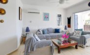 Cyprus Villa Rent with Cozy and elegant living room with blue decor, wooden coffee table, and natural light.