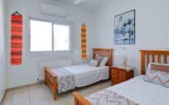 Modern and cozy twin bedroom with minimalist decor and vibrant accents in Cyprus Villa Rent