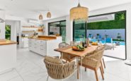 Modern kitchen and dining area with seamless indoor-outdoor connection and natural elements.