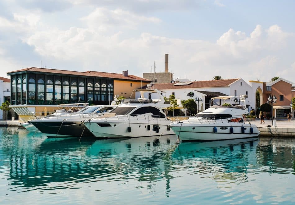 Luxurious yachts docked in serene Limassol Marina on a bus route.